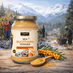 Jar of sea buckthorn powder with a spoonful on a wooden surface, mountainous background